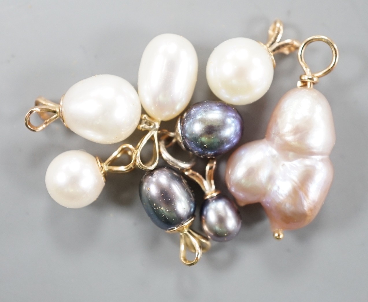 Seven assorted modern yellow metal mounted cultured pearl pendants and a similar white metal mounted pendant, largest 23mm.